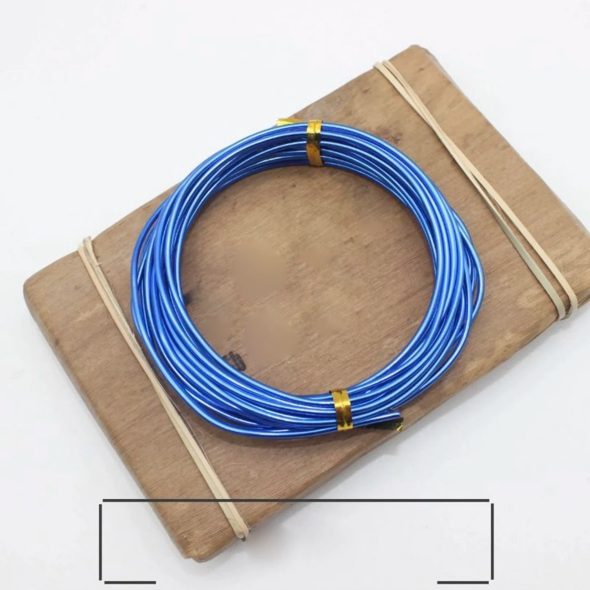 Blue anodized aluminum jewelry wire coiled on a wooden board with thin twine.