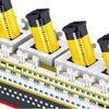 A close-up view of a Titanic ship model kit built with yellow and black blocks.