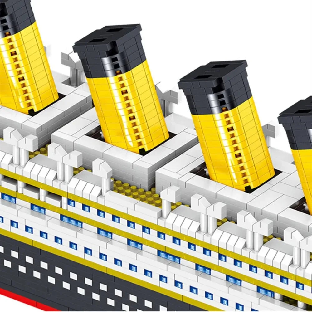 A close-up view of a Titanic ship model kit built with yellow and black blocks.