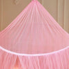 Pink ceiling-hung dome mosquito net with gathered fabric and a single door