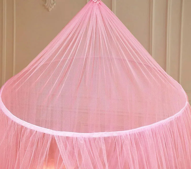 Pink ceiling-hung dome mosquito net with gathered fabric and a single door