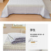 A purple floral quilted bedspread with a light gray border displayed on a bed.