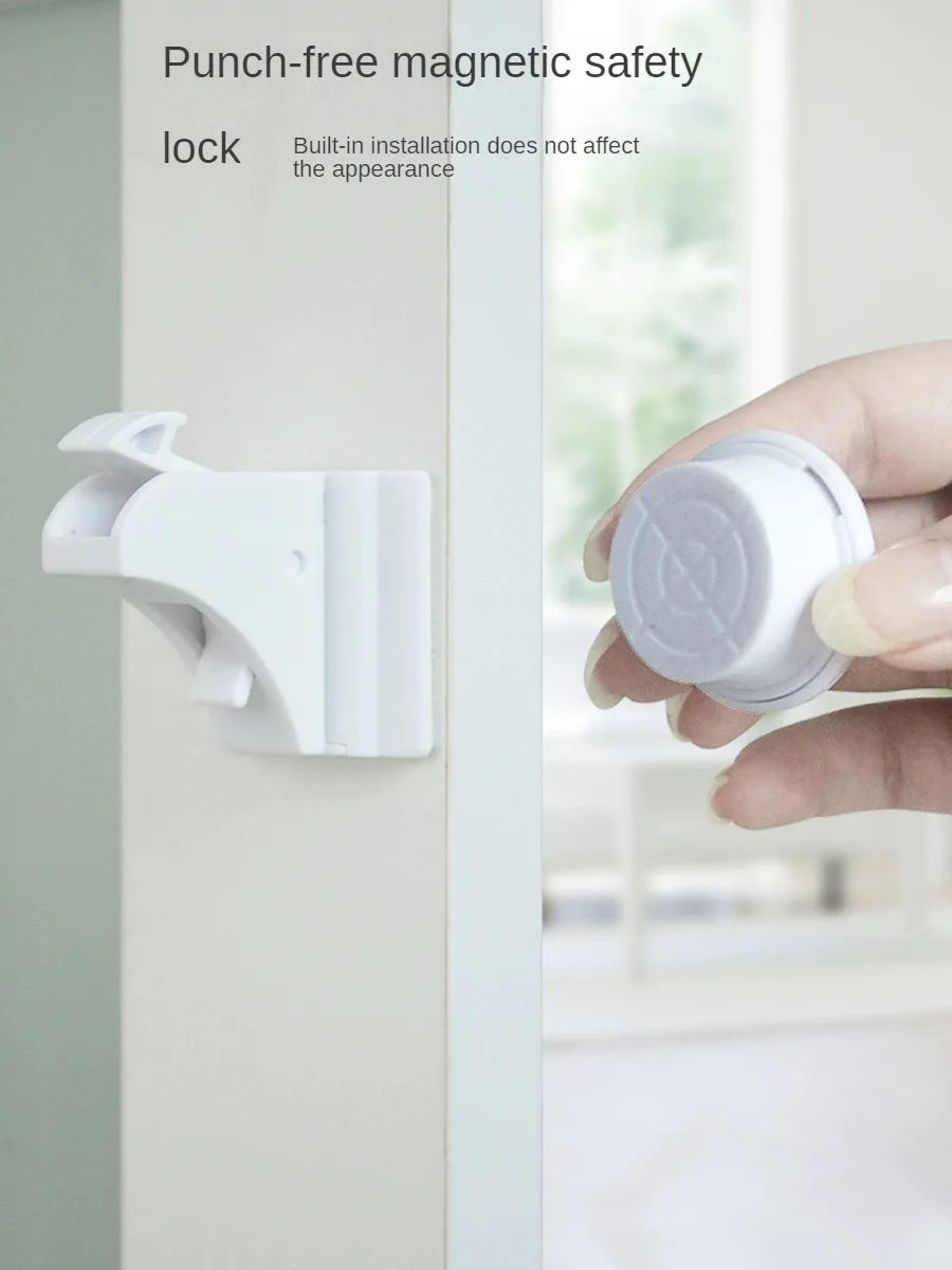 A hand holds a white magnetic safety lock designed for built-in installation.