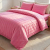 Pink satin striped jacquard duvet cover set with matching pillows on a bed.