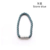 A close-up of a stone blue rope tieback with a silver magnetic clasp.