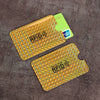 A set of ten yellow and orange RFID blocking card sleeves placed on a dark brown textured surface.