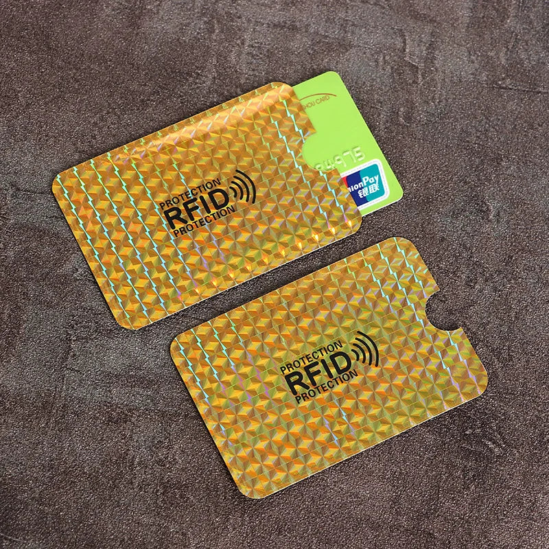 A set of ten yellow and orange RFID blocking card sleeves placed on a dark brown textured surface.