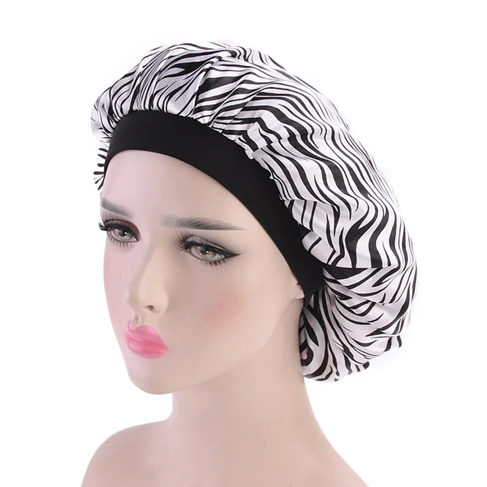 A woman wearing a black satin hair bonnet with a zebra print fabric on a mannequin head.