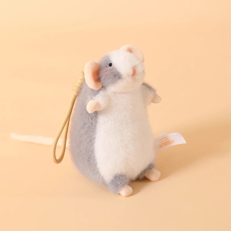 A small, fluffy gray and white plush mouse stuffed animal with a light yellow keychain loop.