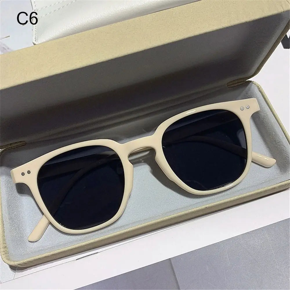 Vintage square sunglasses with light beige frames and dark lenses displayed in a box.