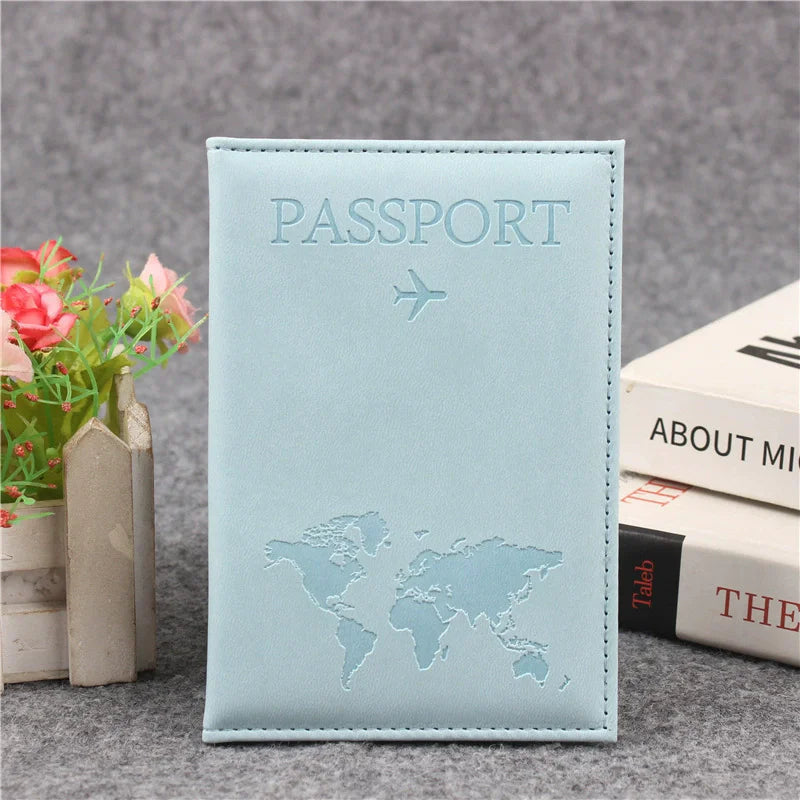Light blue leather passport holder with embossed world map and airplane design