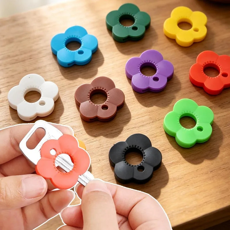 A hand holds a silicone flower key cover in various colors, demonstrating colorful protectors for easy key identification.