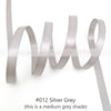 Silver grey satin ribbon roll showing various lengths and folds