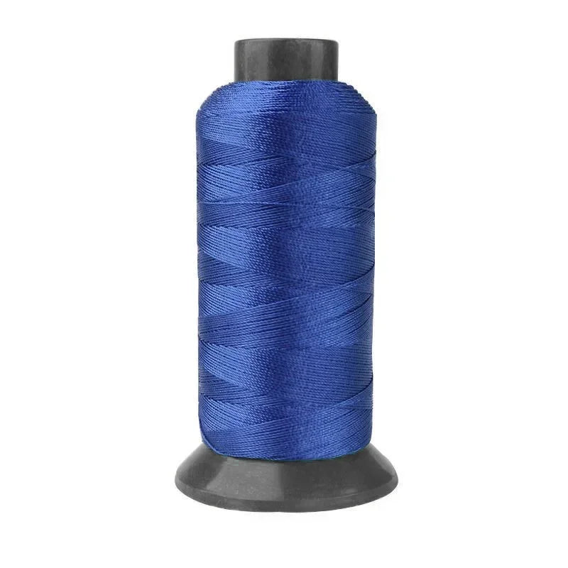 A spool of deep blue heavy-duty nylon sewing thread for upholstery and denim.