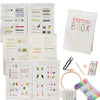 A collection of embroidery stitch books and tools including various thread types, needles, and a finished embroidered piece.