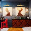 A modern interior featuring two framed abstract art pieces above a dark wooden cabinet and a red chair.