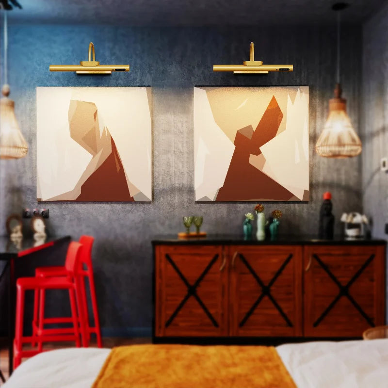 A modern interior featuring two framed abstract art pieces above a dark wooden cabinet and a red chair.