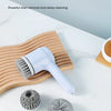 A cordless electric spin scrubber with five interchangeable brush heads is shown on a white marble surface.
