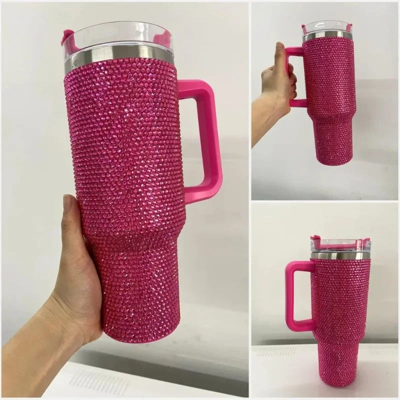 A close-up view of a pink rhinestone bling tumbler with a straw and handle being held by a hand.
