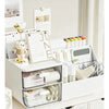 A white desktop compartment storage box with multiple transparent drawers and various office supplies.
