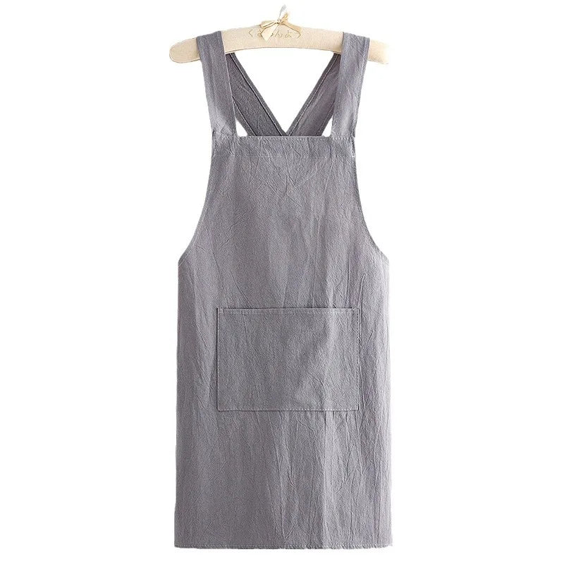 A gray linen kitchen apron hanging on a wooden hanger.