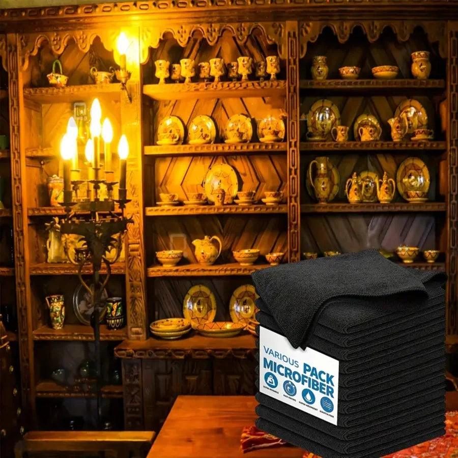 A stack of black microfiber cleaning cloths displayed in a wooden cabinet setting.