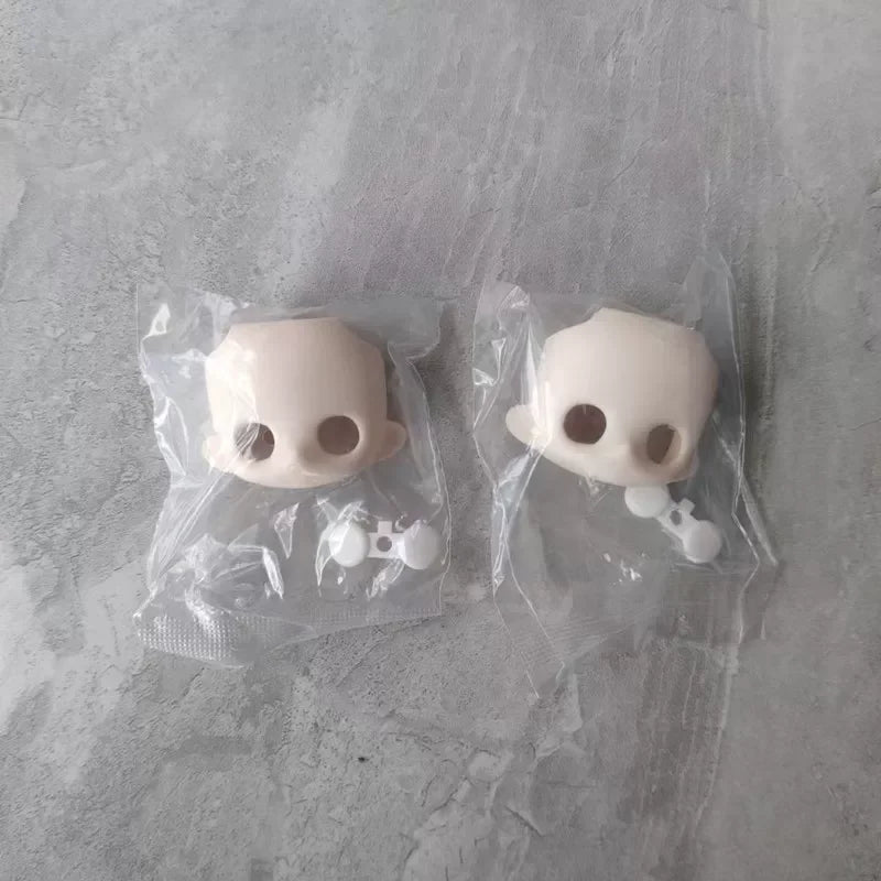A pair of white articulated BJD collectible figurines packaged in clear plastic bags