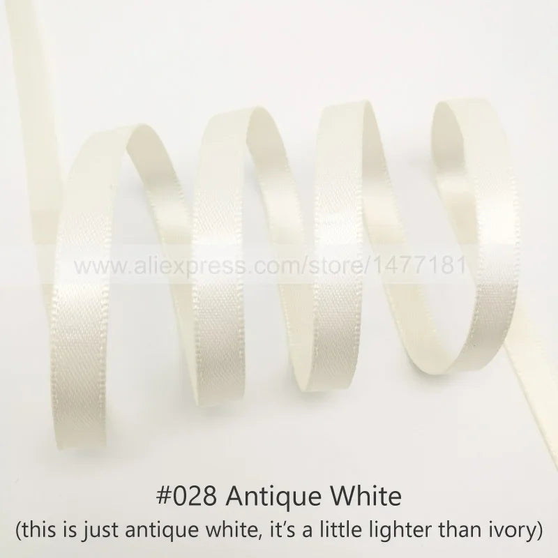 A roll of antique white satin ribbon shown in a wavy line against a white background.
