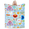 A person is holding a colorful flannel throw blanket featuring monsters and party themes for a Monster Party!