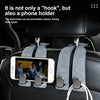A dual hook phone holder is mounted on a car seat, showing its function for holding a smartphone.