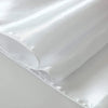 A close-up of an elegant white satin table runner fabric folded and draped.
