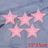 Set of five pink glitter star iron-on embroidered patches on a denim fabric.