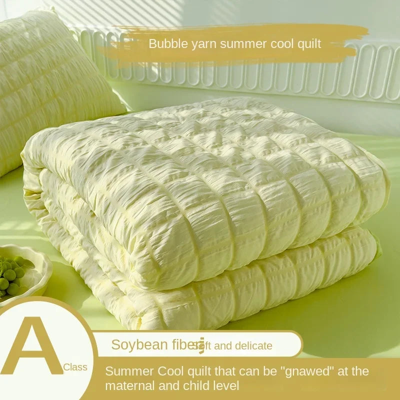 A stack of yellow bubble yarn summer cool quilt fabric next to a label describing its use for maternal and child level gnawin