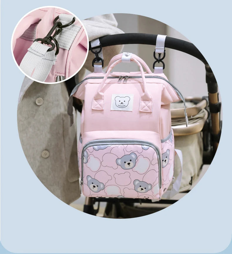 Pink bear print waterproof diaper backpack shown in detail with a close-up of the strap and main compartment.