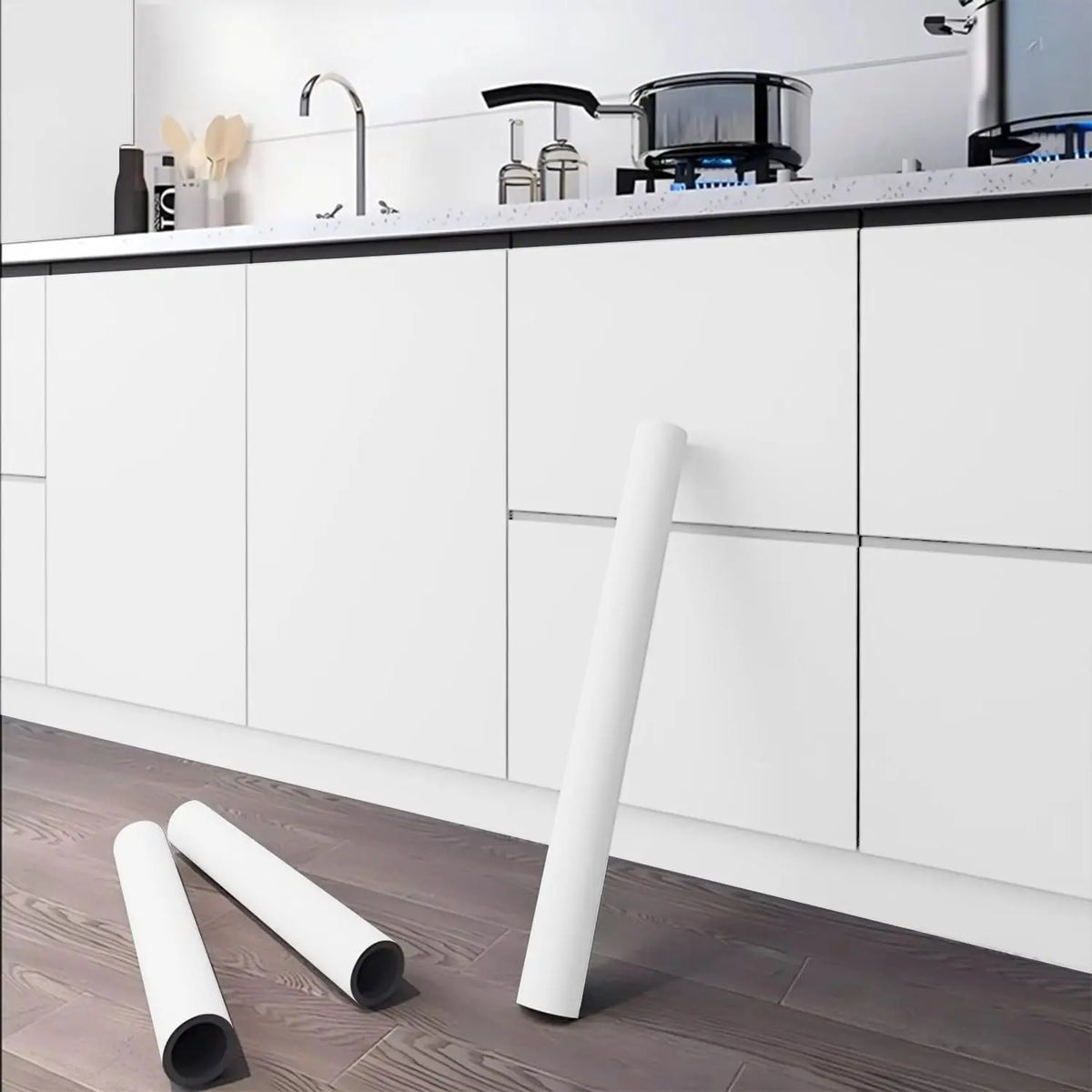 A roll of white self-adhesive peel-and-stick wallpaper lying on a dark wooden floor.