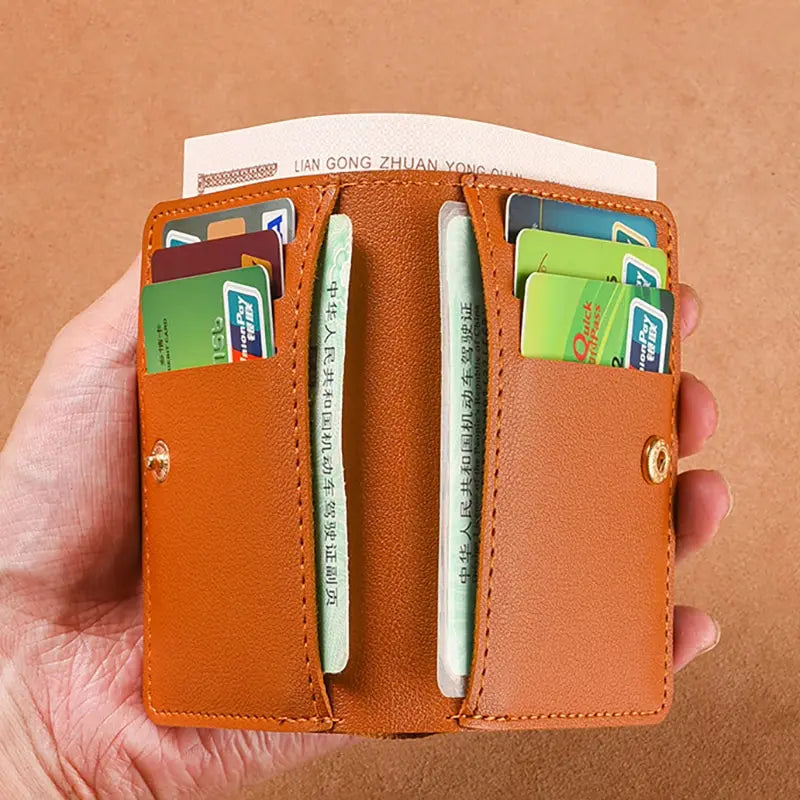 An orange leather compact wallet holding several credit cards and an ID card.