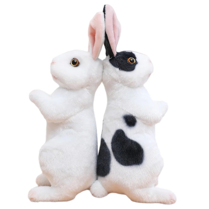 A pair of white and black lifelike plush rabbit stuffed animals standing side by side.