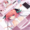 Anime girl illustration on a pink mouse pad featuring pink hair and white clothing