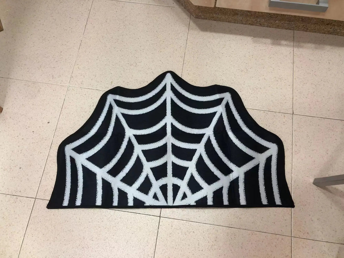 Black and white decorative rug shaped like a spider web with a ghost design