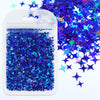 A clear plastic pouch filled with iridescent blue and purple holographic star sequins scattered next to the container.