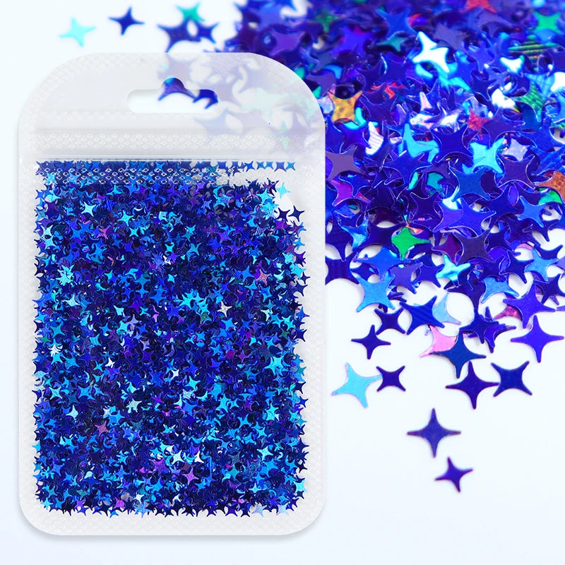 A clear plastic pouch filled with iridescent blue and purple holographic star sequins scattered next to the container.