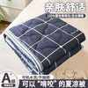 A folded navy blue quilted blanket with white stitching and a label indicating it is suitable for summer.