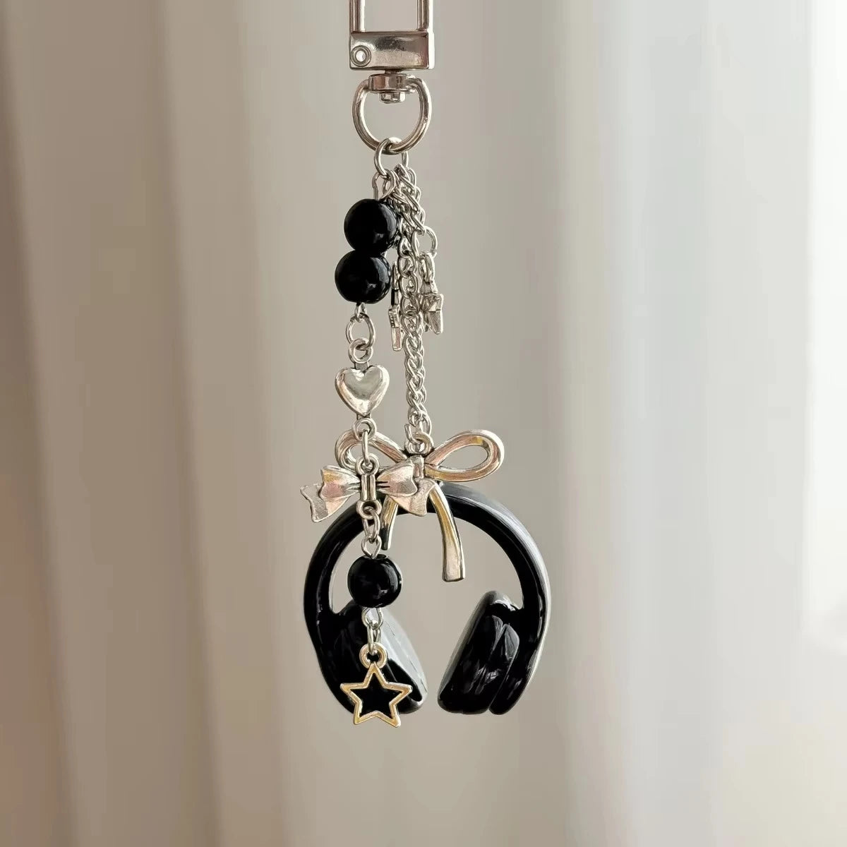 Silver metal music note charm with black beads and a bow detail