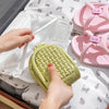 Hands are opening a lime green foldable EVA travel slipper for home or hotel use.