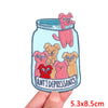 An embroidery patch featuring a pink cartoon cat and several small, distressed-looking dog characters.