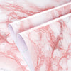 Rolls of pink and white marble wallpaper showing the natural veining pattern.
