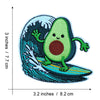 An embroidered patch depicting a green avocado character swimming in a blue sea wave.
