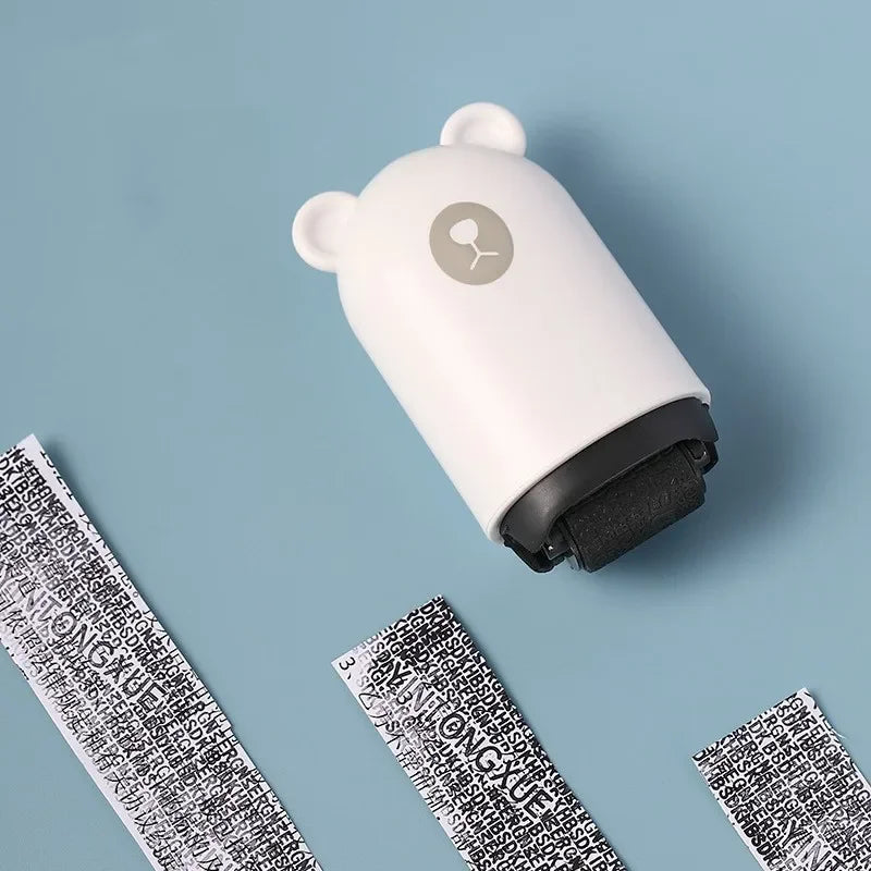 Un tampon roulant blanc avec un haut gris clair et une base noire est montré sur un fond bleu clair.