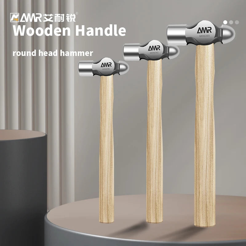 Three AMR round head hammer handles with wooden grips and silver heads displayed on a surface.