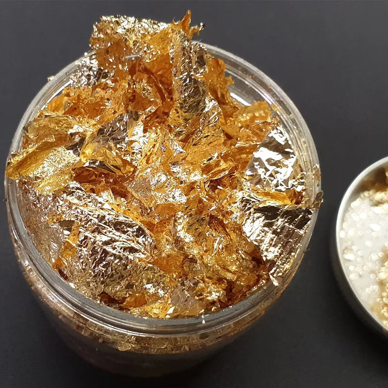 A clear jar filled with gold metallic foil flakes for crafting projects.
